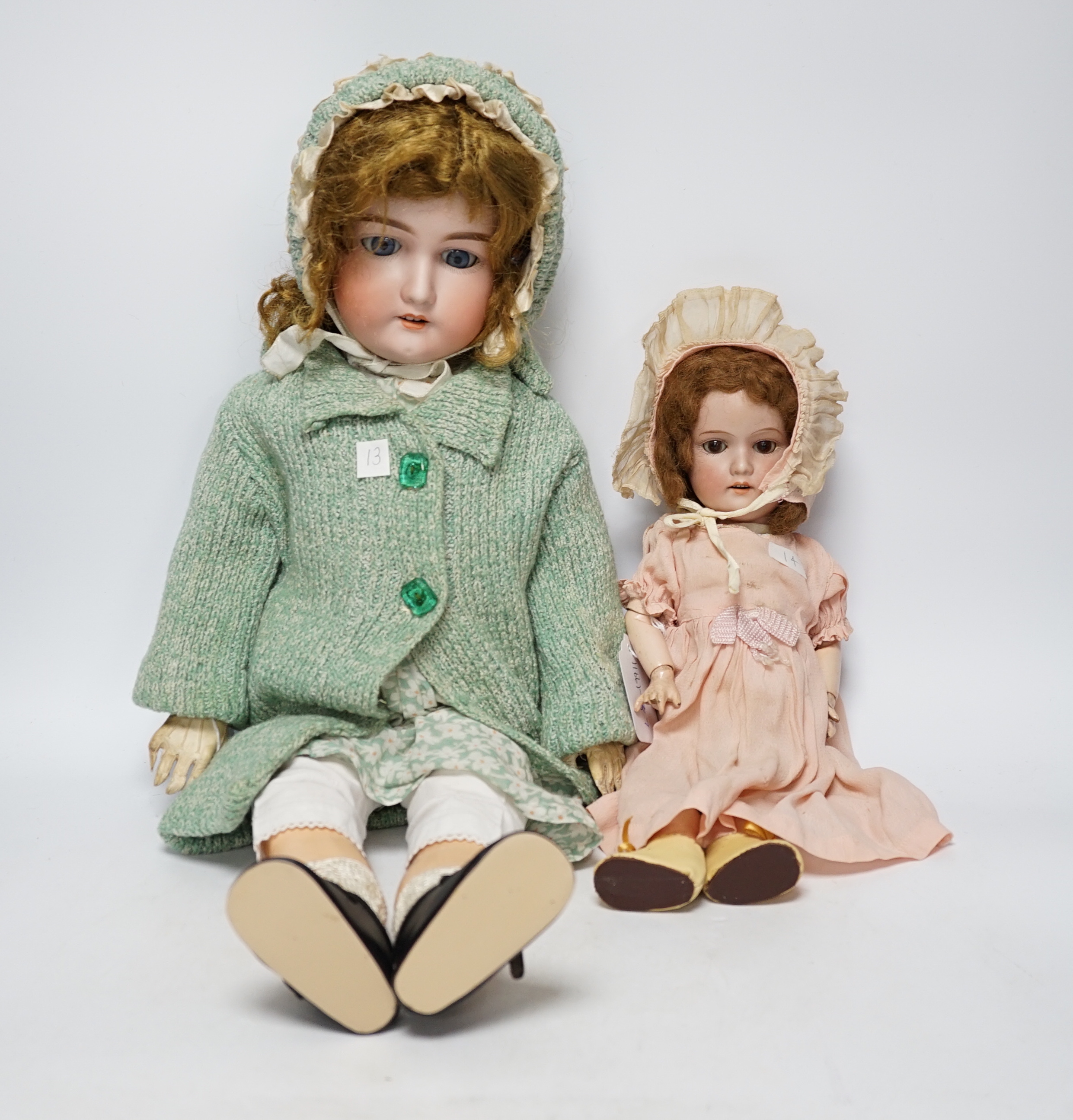 An AM390 bisque head doll, 63cm good condition, and an AM390, missing two fingers and wear on other hand, 58cm